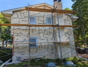 Before image to a house with stucco cracks repaired but needing paint