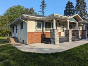 Before picture of a house in need of stucco patching and painting