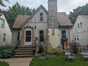 Before image of a home in need of stucco repair and paint service