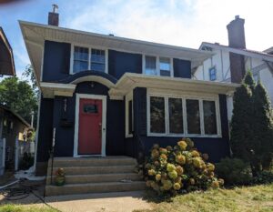 After image of a home after stucco repair and dark paint applied