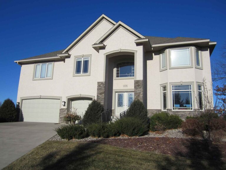Front view of two story house with light colored stucco paint