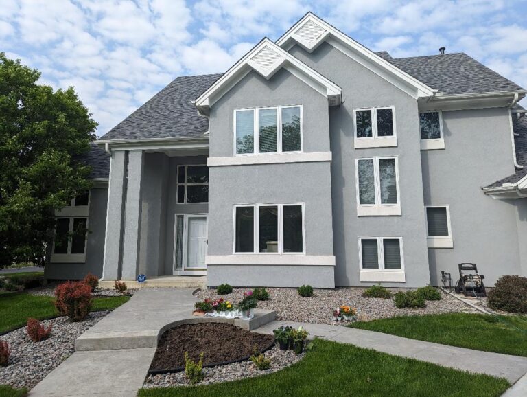 Image of 2-story house with sharp stucco paint in gray