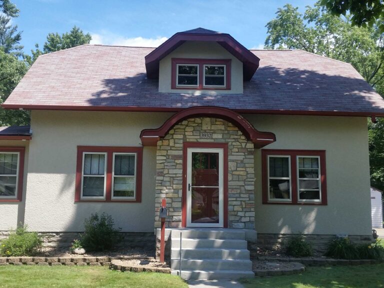 Image of a house that underwent home stucco painting service with red trim