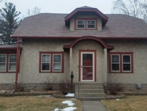 view of the front of a home in need of stucco painting service