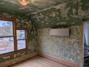 View of bedroom with major plaster damage in need of repair