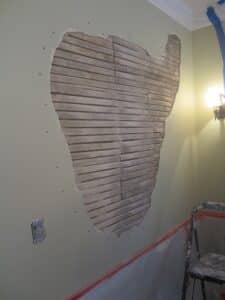 view of a hole on a plaster wall before repairs made